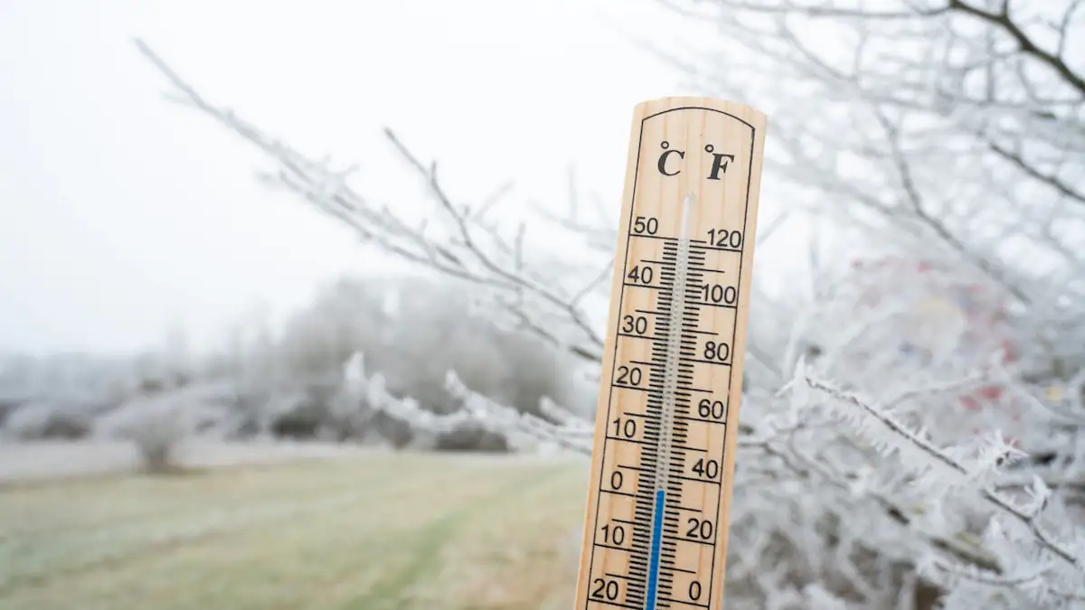 Eisheilige 2026: Thermometer zeigt geringe Temperaturen, im Hintergrund frostige Landschaft