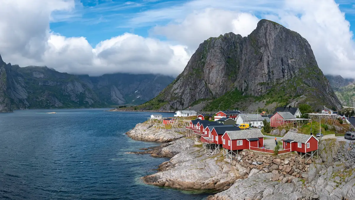 Reiseziele: Fischerdorf Hamnoy auf den Lofoten, Norwegen, mit bunten Häusern an tiefblauem Wasser