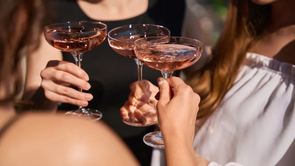 Frauen stoßen mit Alkohol an