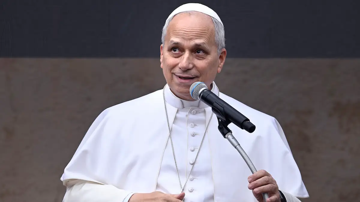 Papst Leo XIV. hält im weißen Gewand in eine Rede an einem Mikrofon