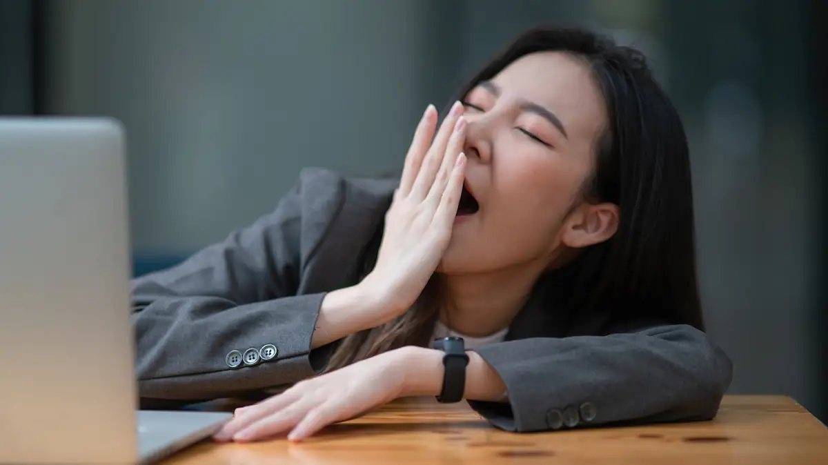 Power Nap Contest Symbolbild: Asiatische Frau gähnt müde am Schreibtisch