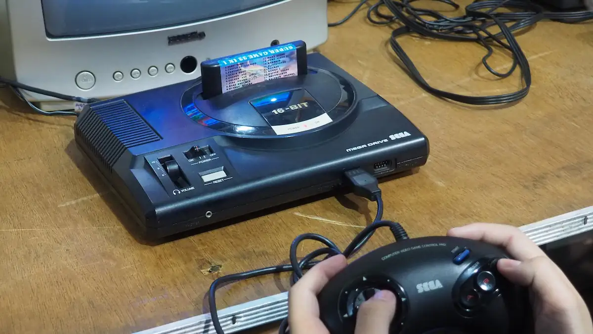 Jemand spielt mit dem Sega Mega Drive und einem Controller