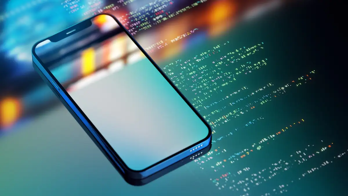Smartphone Trojaner: Smartphone liegt mit spiegelndem Display auf Code-Zeilen