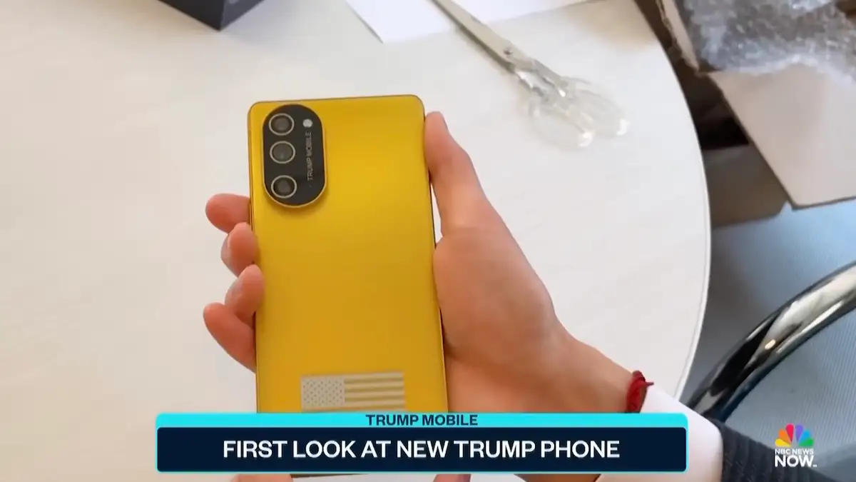 Reporter hält das goldene Trump-Smartphone T1 in der Hand und zeigt die Rückseite
