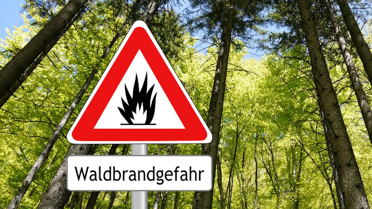 Schild im Wald warnt vor Waldbrandgefahr