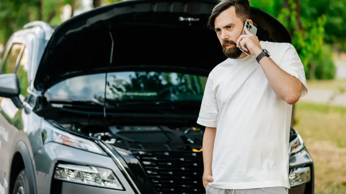 Gefahr für den Motor: Mann steht vor einer geöffneten Motorhaube