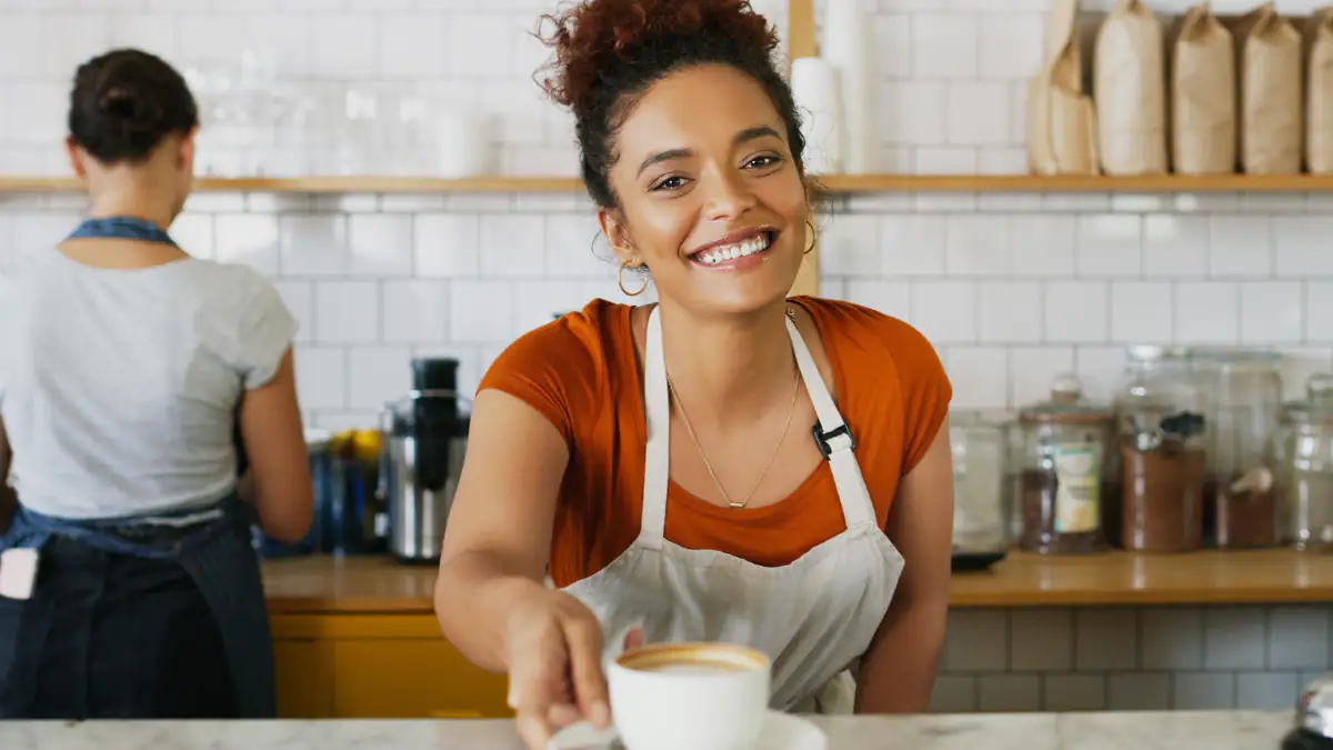 Frau verkauft Kaffee in einem Café