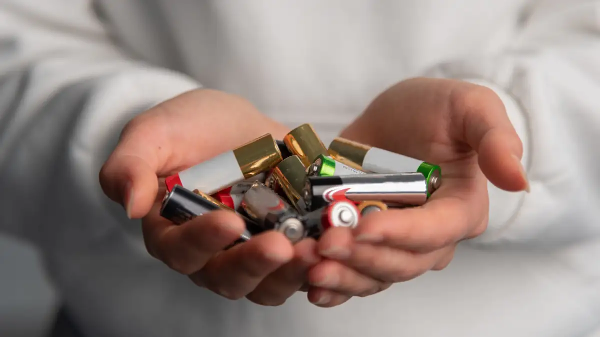 Jemand hält viele Batterien in den geöffneten Händen