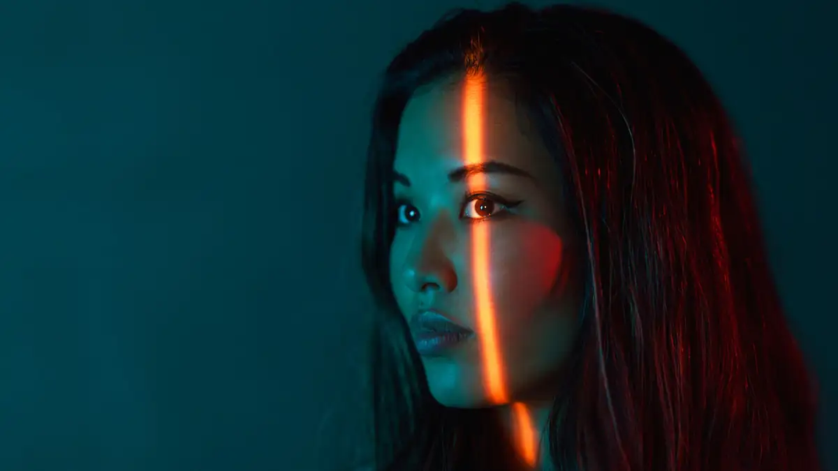 Dark Patterns: Lichtstreifen auf dem Gesicht einer Frau