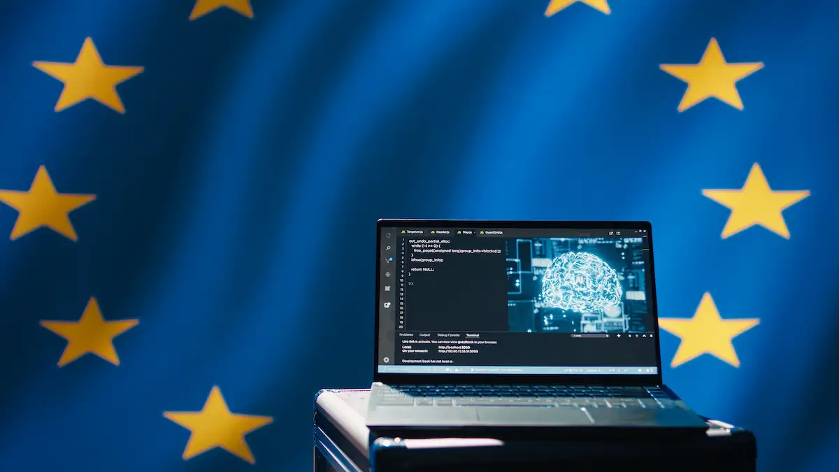 Rechner mit KI-Software, dahinter die Europaflagge