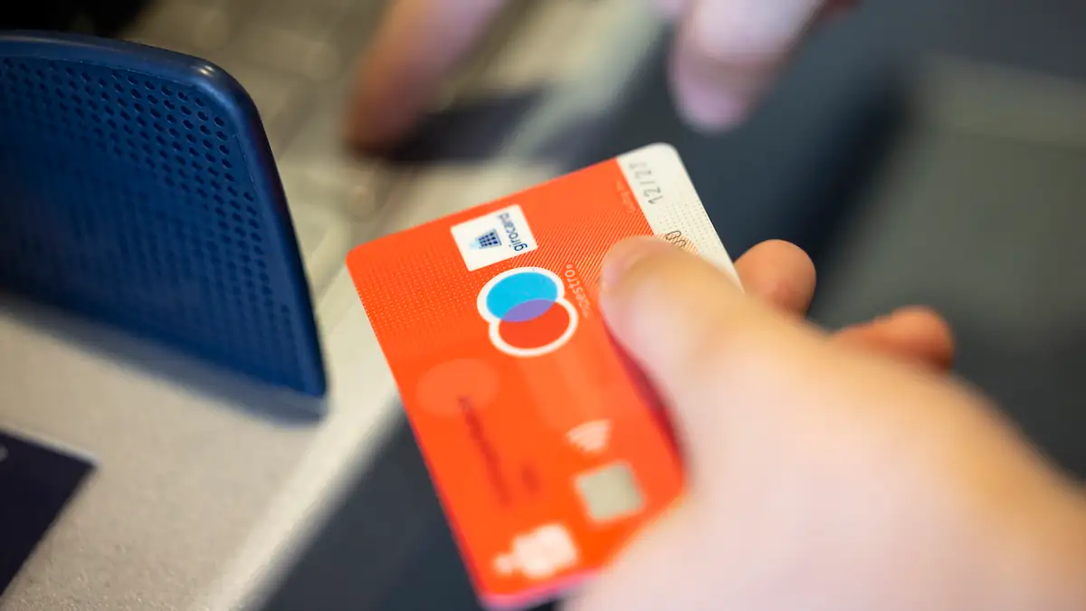 Jemand verwendet eine rote Girocard am Bankautomaten