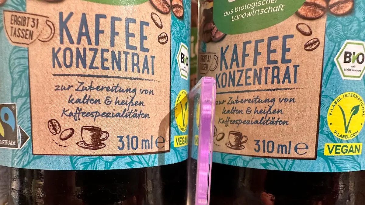 Flaschen mit Kaffeekonzentrat stehen in einem Drogeriemarktregal.
