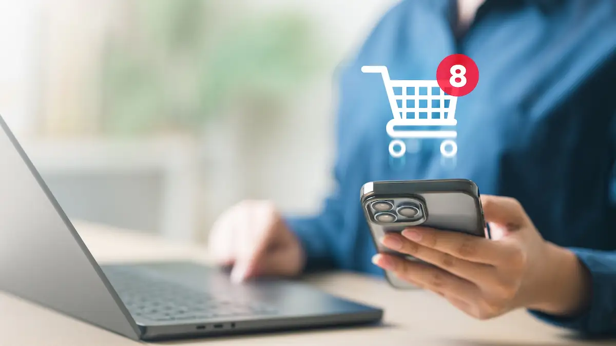 Amazon Prime Day 2026: Jemand sitzt an einem Laptop, über dem ein Einkaufswagen-Symbol schwebt