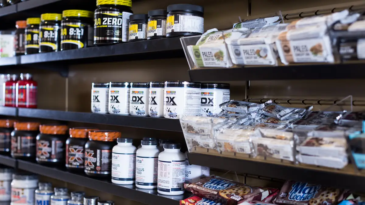 Protein-Produkte wie Eiweißpulver und Riegel in einem Supermarktregal