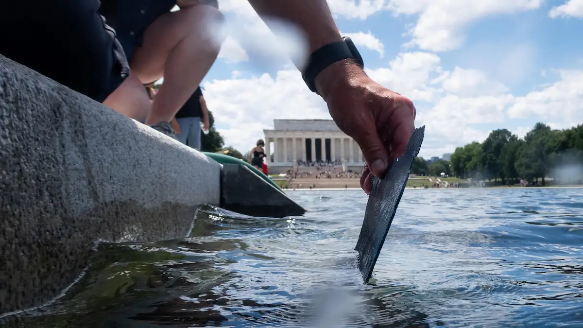 Jemand greift nach einem Stück der abgeblätterten Farbe des Reflection Pool am Lincolm Memorial in Washington D.C.