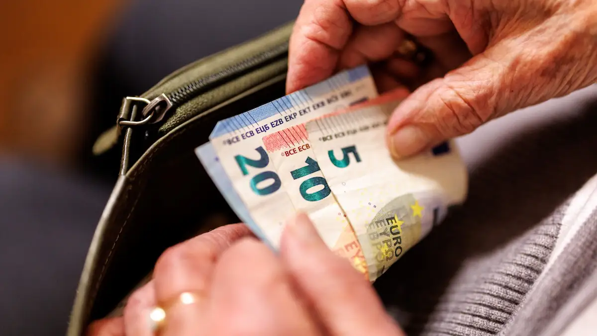 Rentenreform: Geldbeutel mit Euroscheinen in der Hand einer älteren Frau