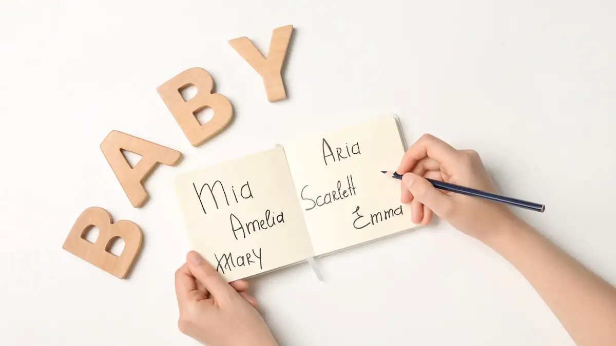 Vornamen: Jemand schreibt auf eine Karte Babynamen