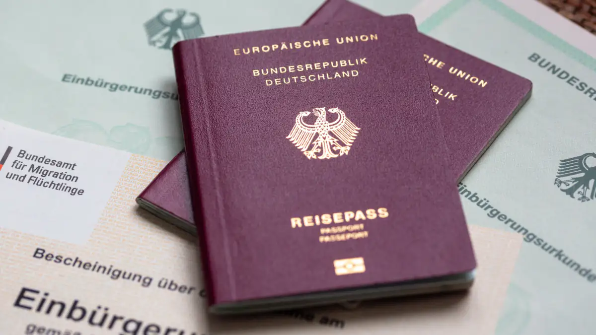 Symbolbild Einbürgerungen: Zwei deutsche Reisepässe liegen auf Urkunden 