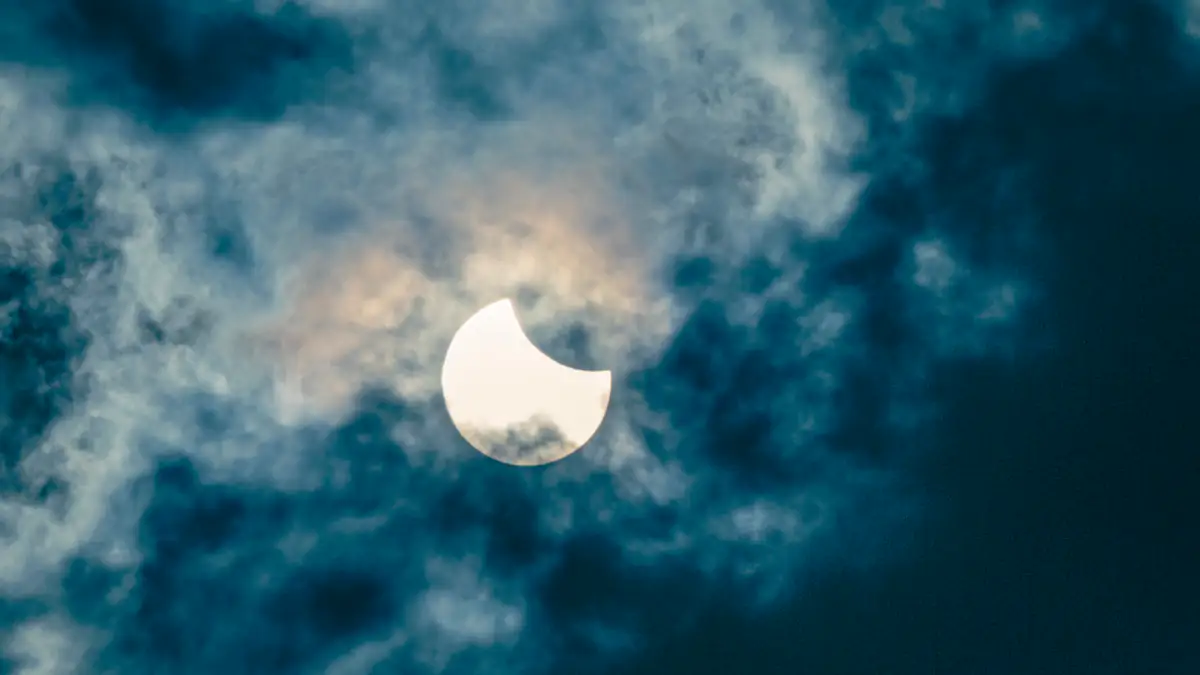 Eine partielle Sonnenfinsternis hinter den Wolken