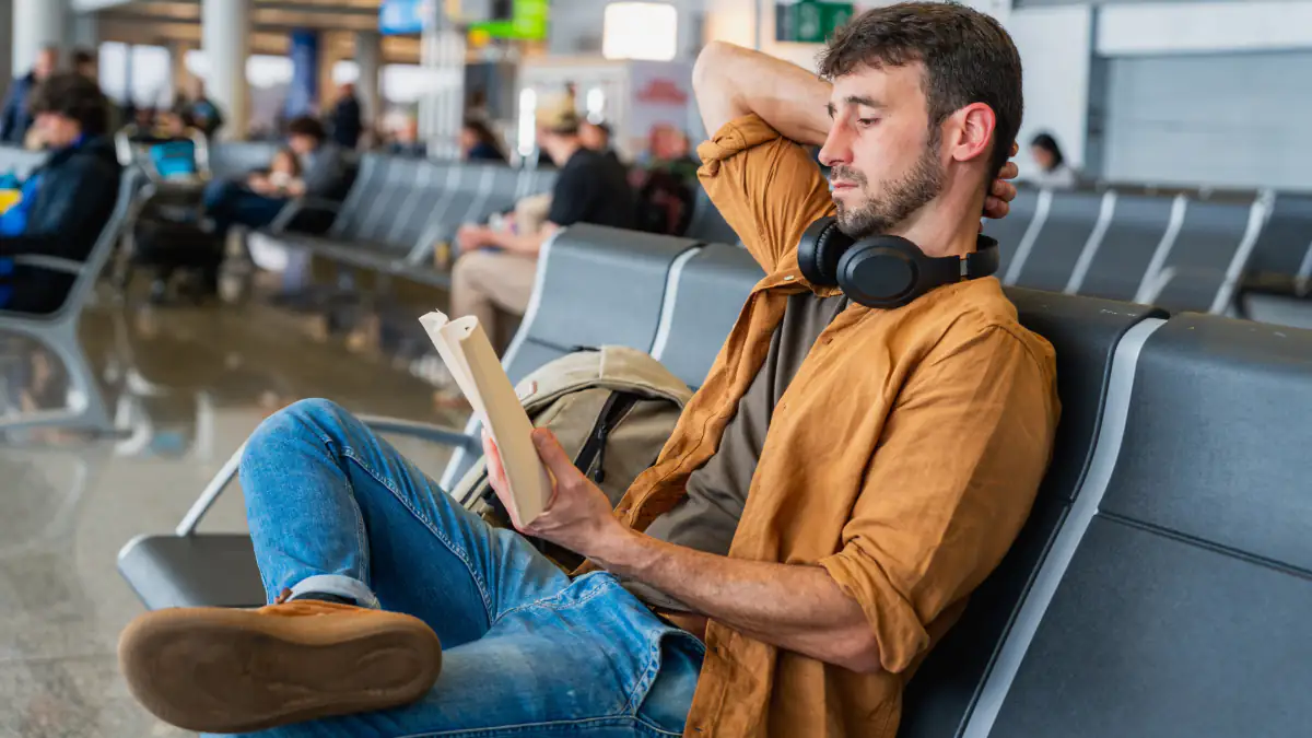 Mann sitzt am Flughafen