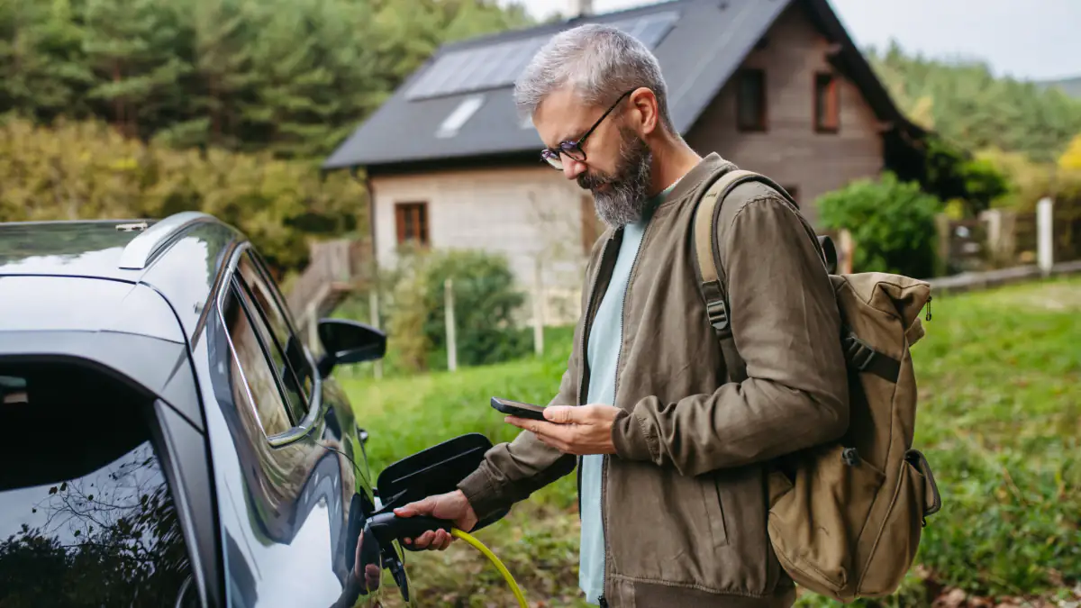 Ein Mann lädt sein E-Auto auf