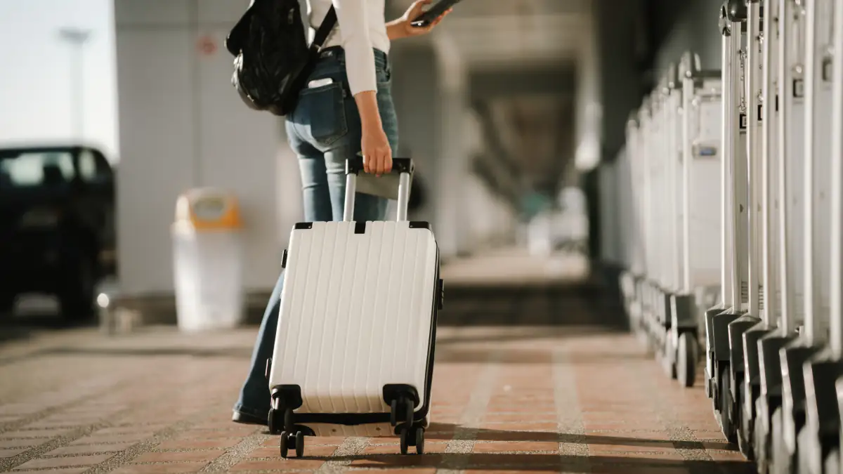 Frau mit einem Koffer am Flughafen