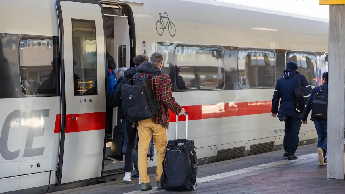 ICE Deutsche Bahn hält an einem Bahnhof und Leute steigen aus