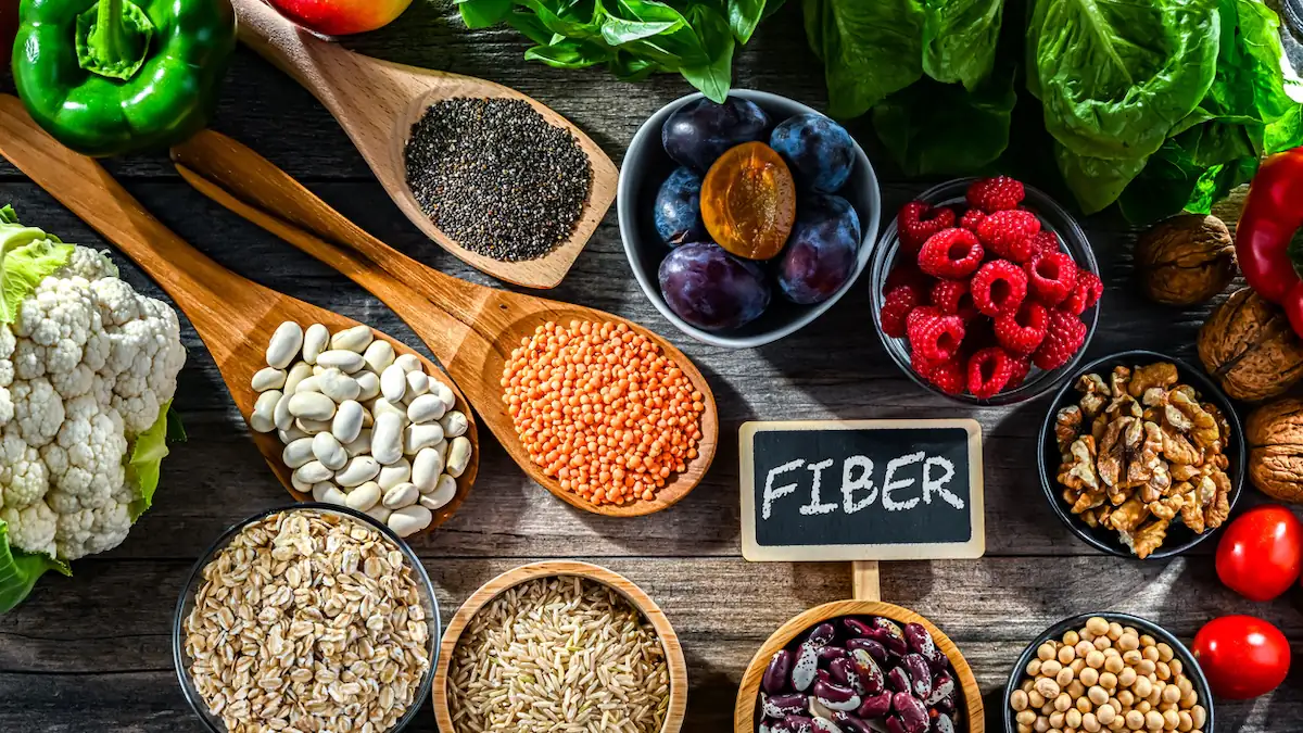Fibermaxxing: Zwischen Schüsseln mit Ballaststoffreichen Lebensmitteln liegt eine Tafel mit dem Wort „Fiber“