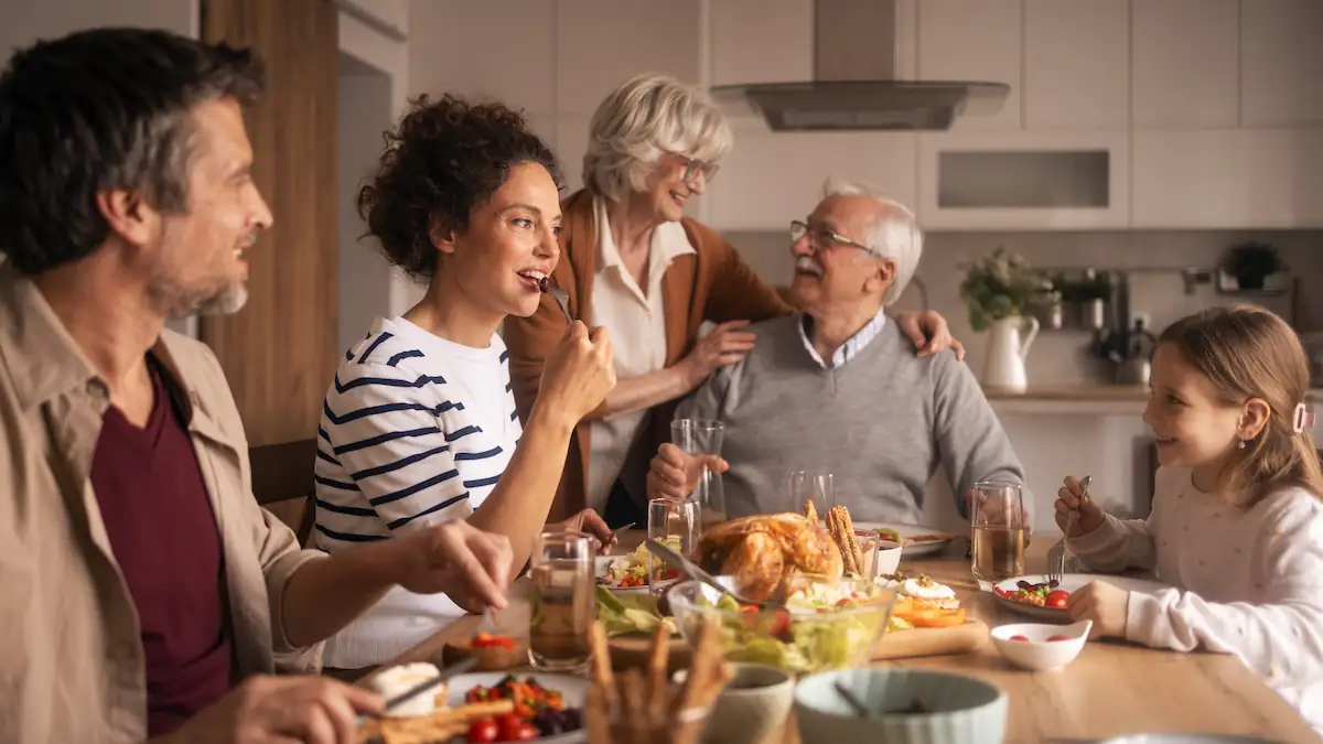 Mehrere Generationen in einer Familie sitzen zusammen beim Essen