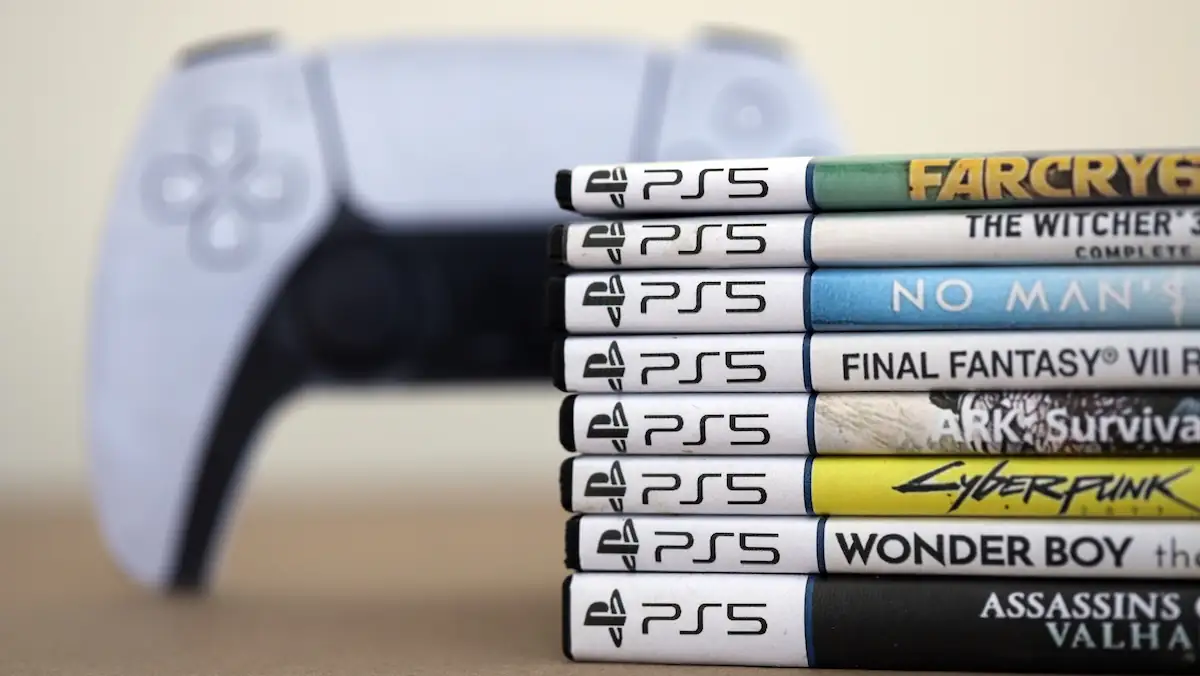 Gestapelte PS5-Spiele von Sony, im Hintergrund ein Controller