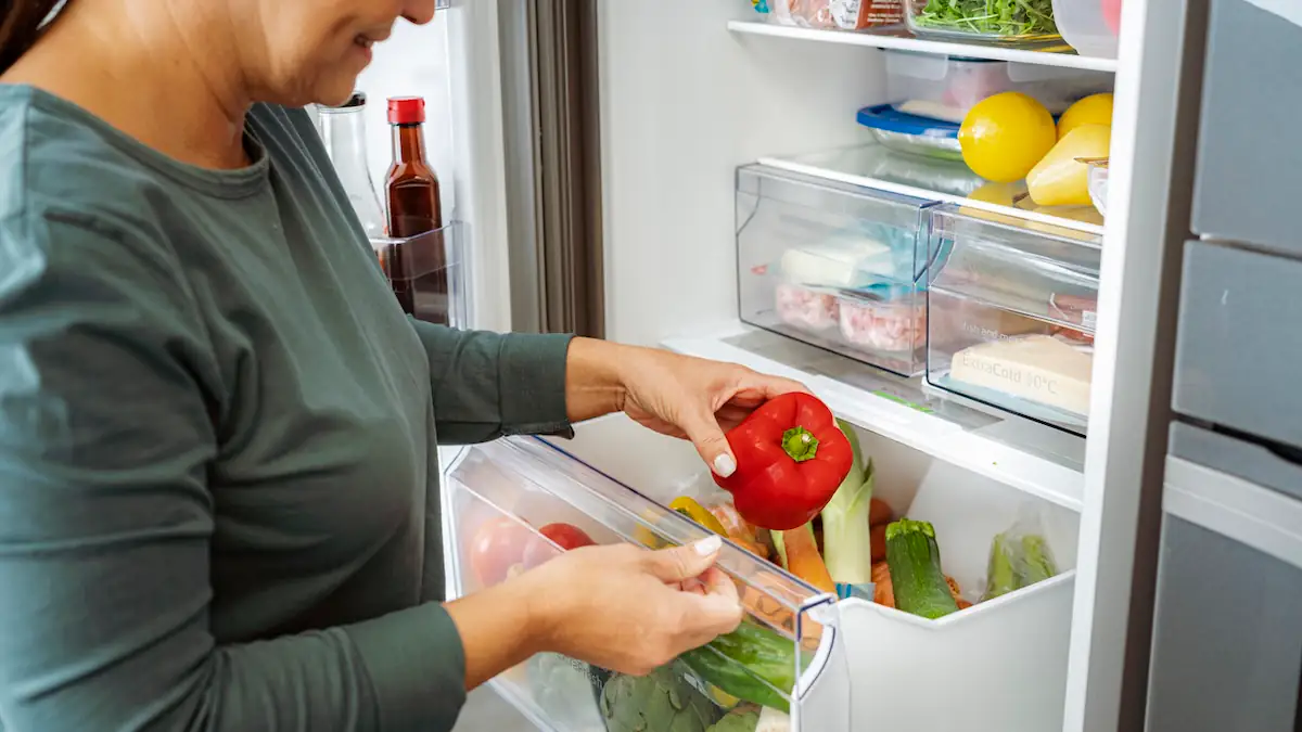 Frau räumt Kühlschrank ein